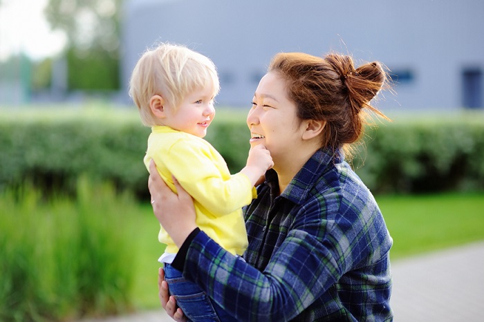 young asian woman with caucasian boy